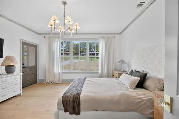 a bedroom with a bed and a flat tv screen on dresser