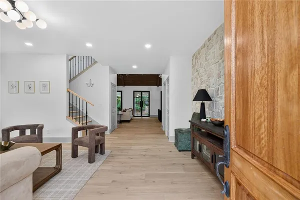 a living room with furniture a flat screen tv and a refrigerator