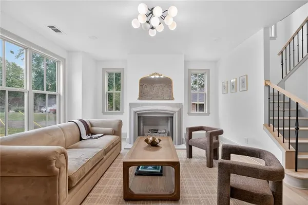 a living room with furniture a fireplace and a large window