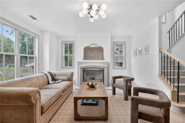 a living room with furniture a fireplace and a large window
