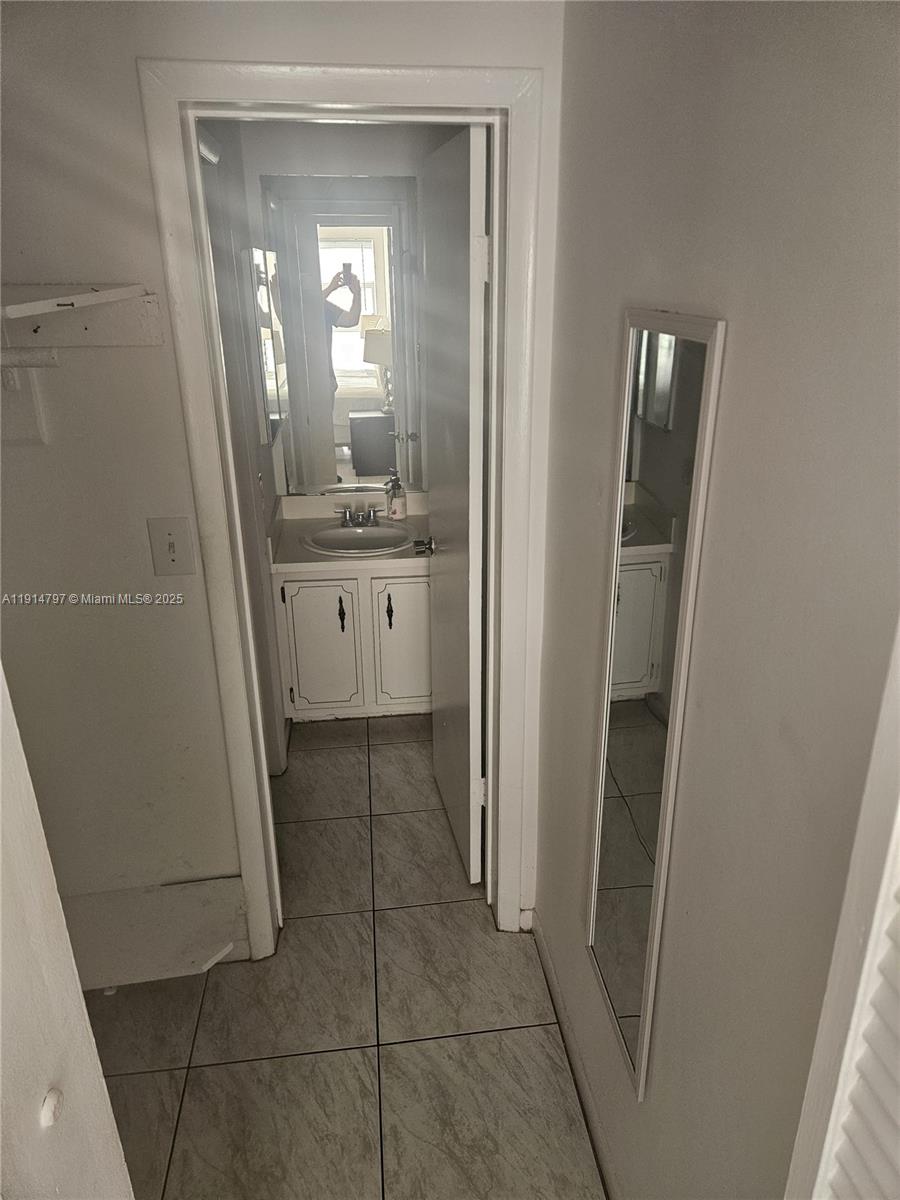 201 178th Drive, Unit 302 Sunny Isles Beach, FL 33160 - Photo 11 of 19 a bathroom with a granite countertop sink a mirror and a vanity