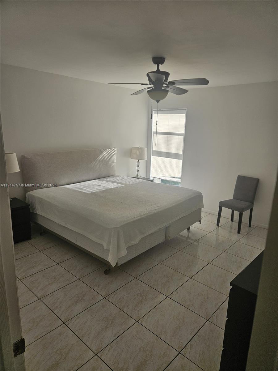 201 178th Drive, Unit 302 Sunny Isles Beach, FL 33160 - Photo 13 of 19 a bedroom with a bed and a chandelier