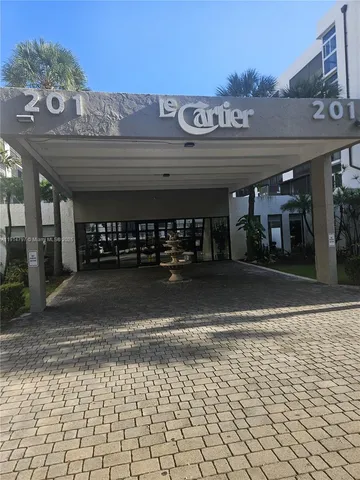 a front view of a building with retail shop and parking space