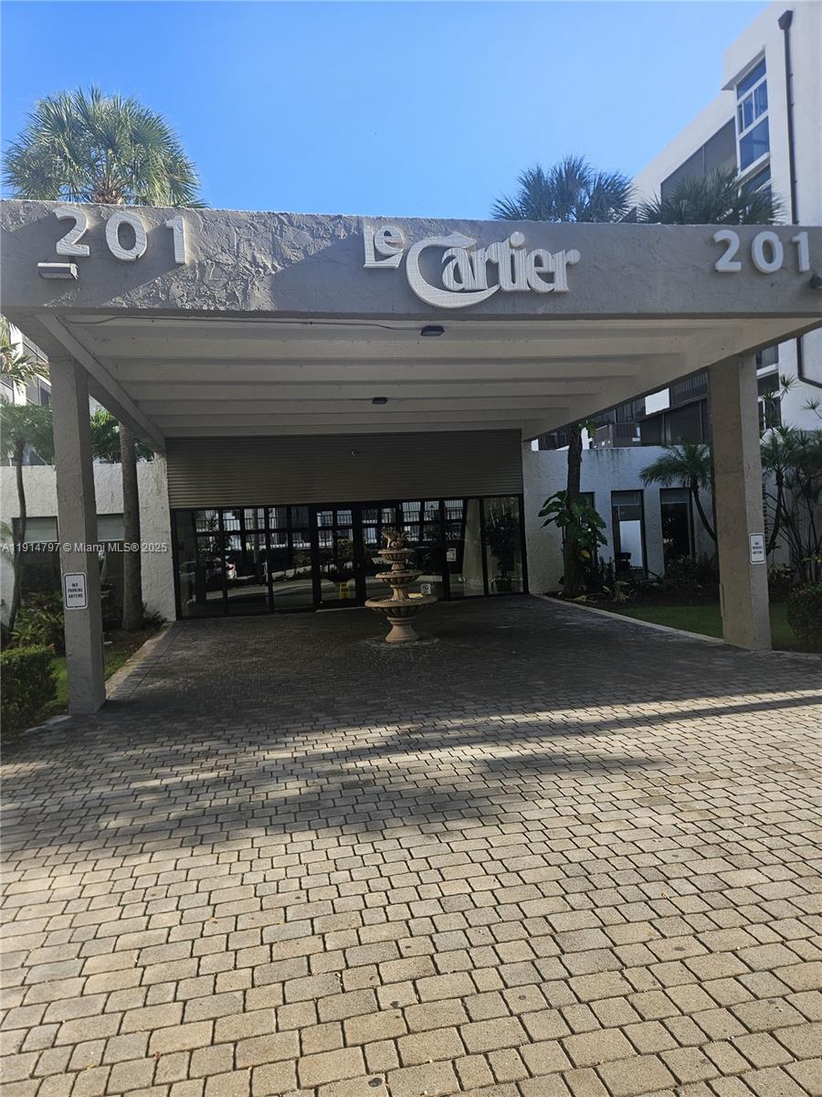 201 178th Drive, Unit 302 Sunny Isles Beach, FL 33160 - Photo 2 of 19 a front view of a building with retail shop and parking space