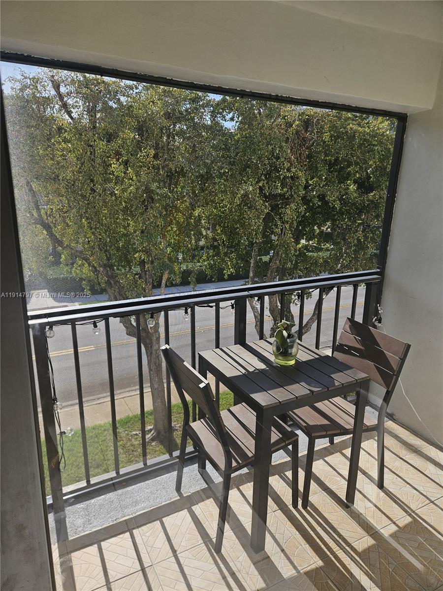 201 178th Drive, Unit 302 Sunny Isles Beach, FL 33160 - Photo 8 of 19 a view of a balcony wooden chairs