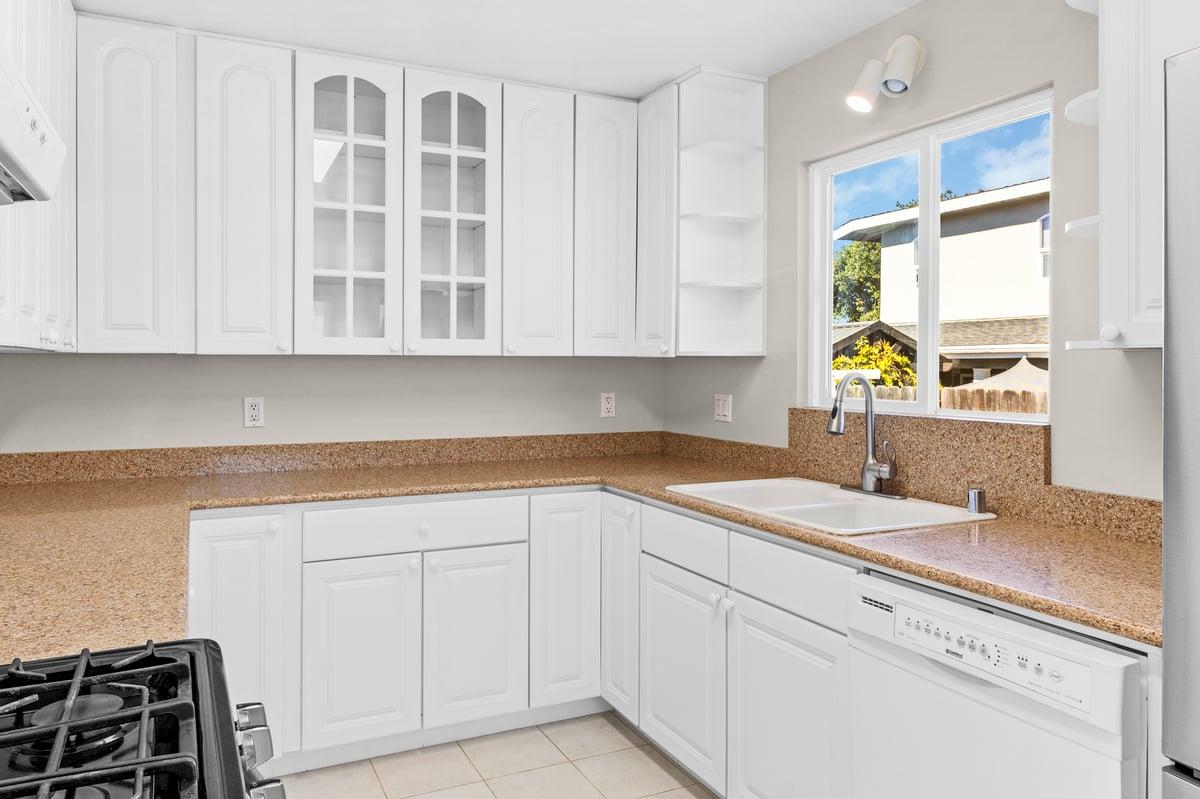 1021 Wheeler Street Seaside, CA 93955 - Photo 8 of 28 a kitchen with granite countertop white cabinets and a sink