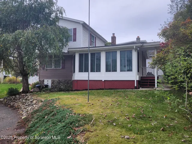 a view of a house with a yard and fence
