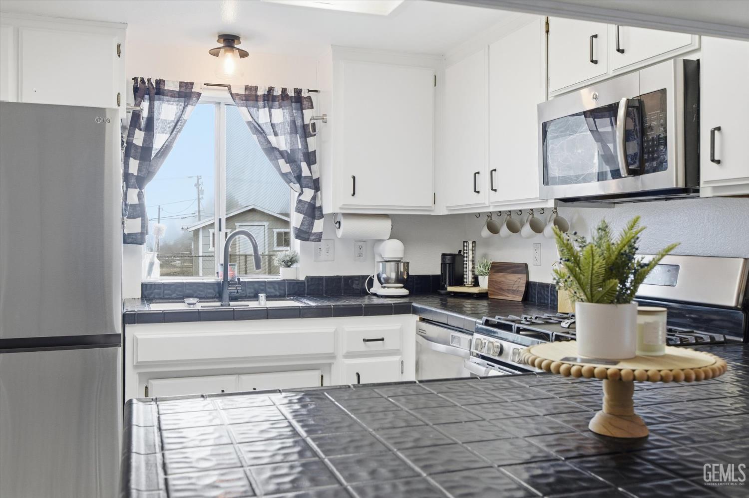 Undisclosed Address Tehachapi, CA 93561 - Photo 20 of 46 a kitchen with granite countertop a sink a stove and cabinets