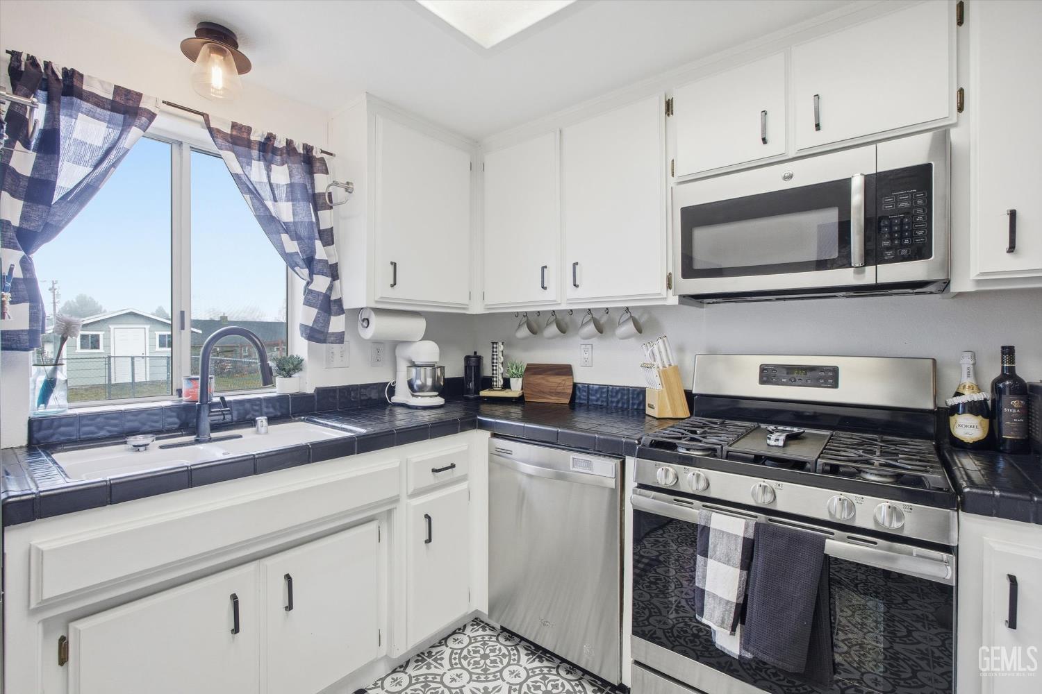 Undisclosed Address Tehachapi, CA 93561 - Photo 21 of 46 a kitchen with stainless steel appliances granite countertop a sink a stove and microwave