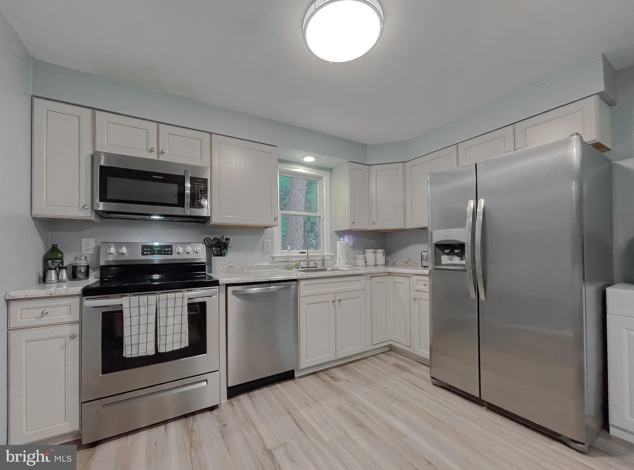 12788 Rio Grande Trail Lusby, MD 20657 - Photo 13 of 29 a kitchen with stainless steel appliances granite countertop a stove a sink and a refrigerator