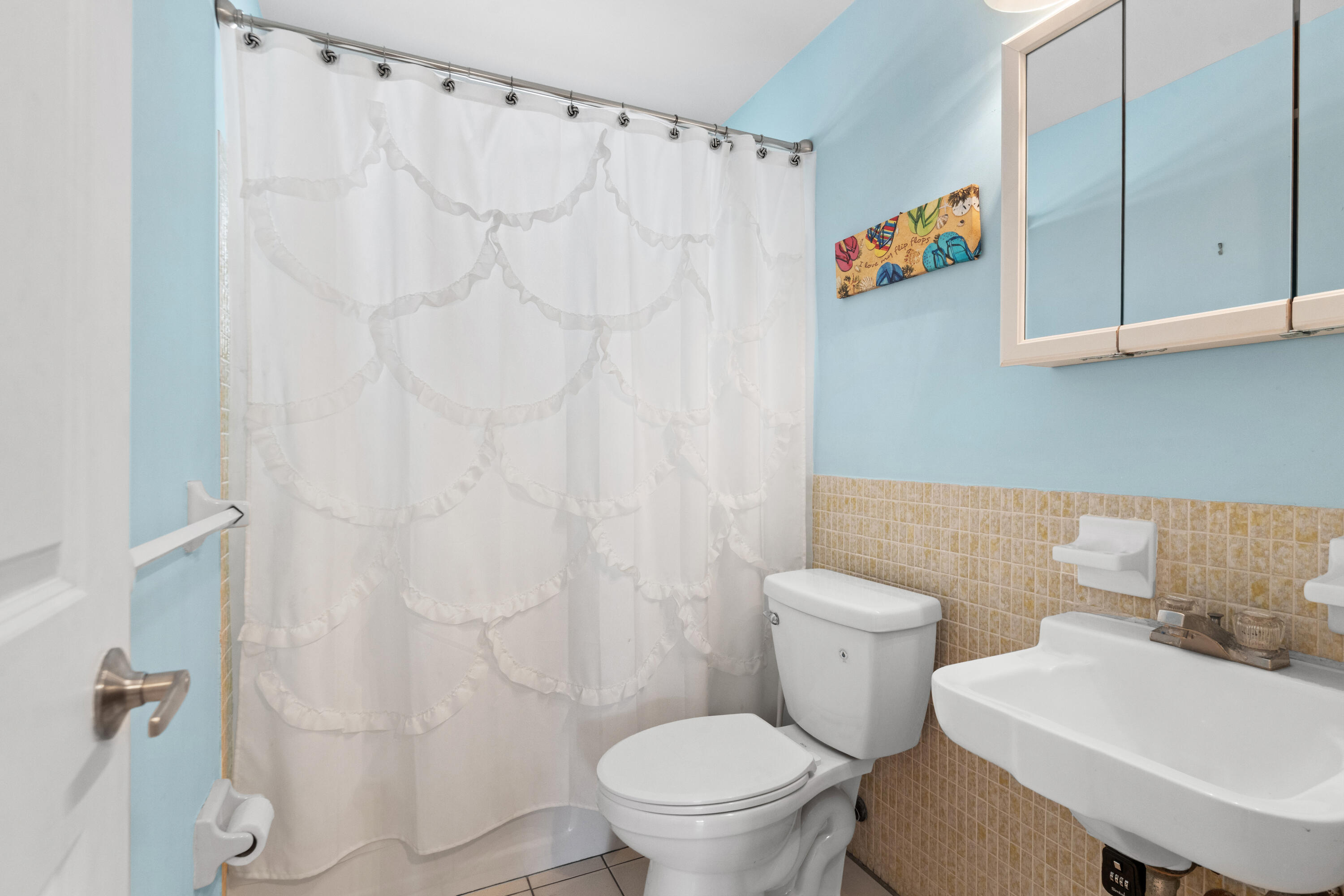 249 Center Street, Unit 2C Jupiter, FL 33458 - Photo 22 of 29 a white toilet sitting next to a bathroom sink