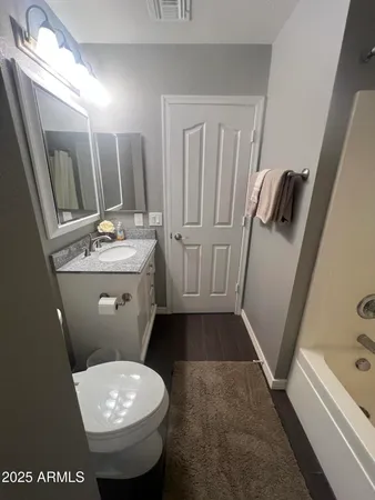 a bathroom with a sink a toilet a mirror and shower