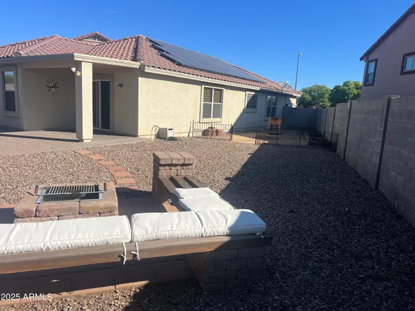 a view of house with backyard and outdoor seating