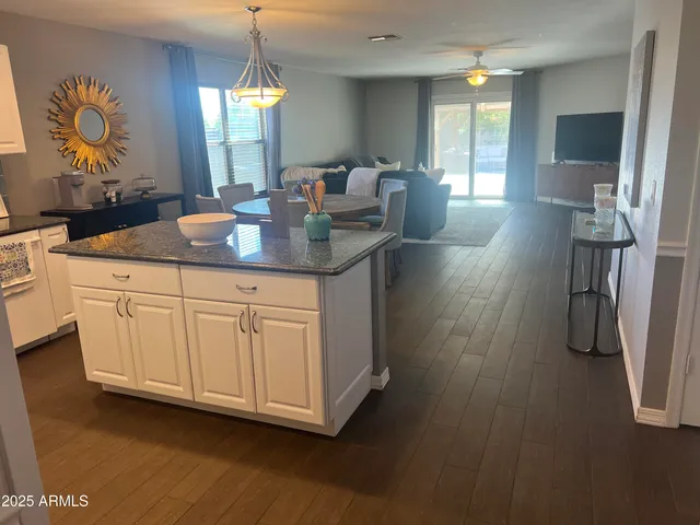 a dining hall with granite countertop a sink dishwasher a dining table and chairs with wooden floor