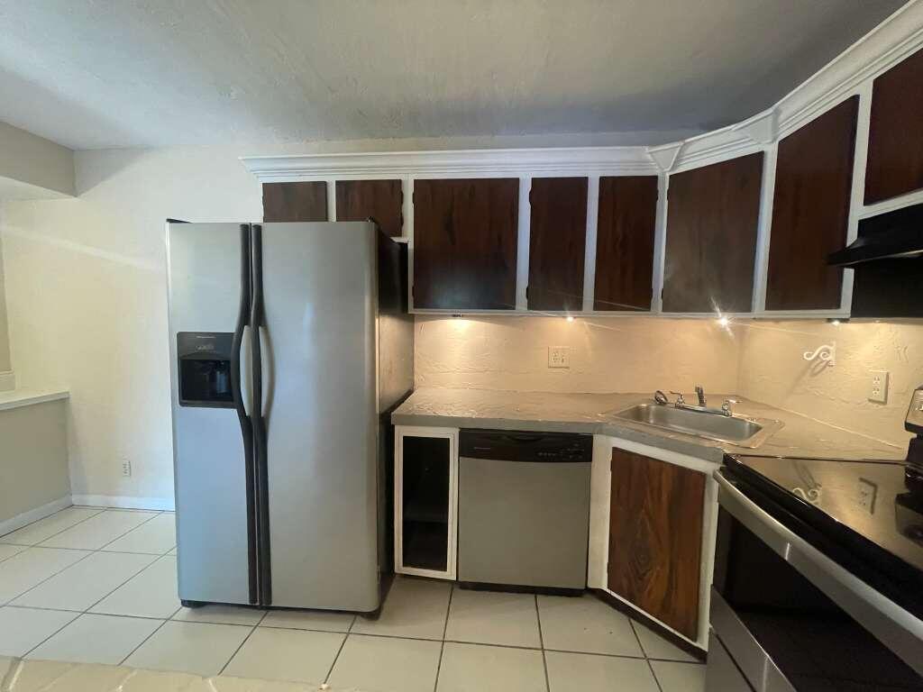 721 Sunny Pine Way, Unit A1 Greenacres, FL 33415 - Photo 2 of 10 a kitchen with stainless steel appliances granite countertop a refrigerator and a stove top oven
