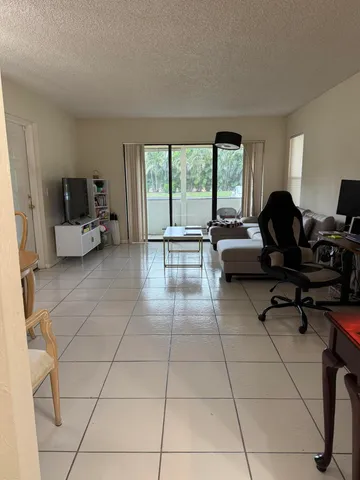 a living room with furniture and a floor to ceiling window