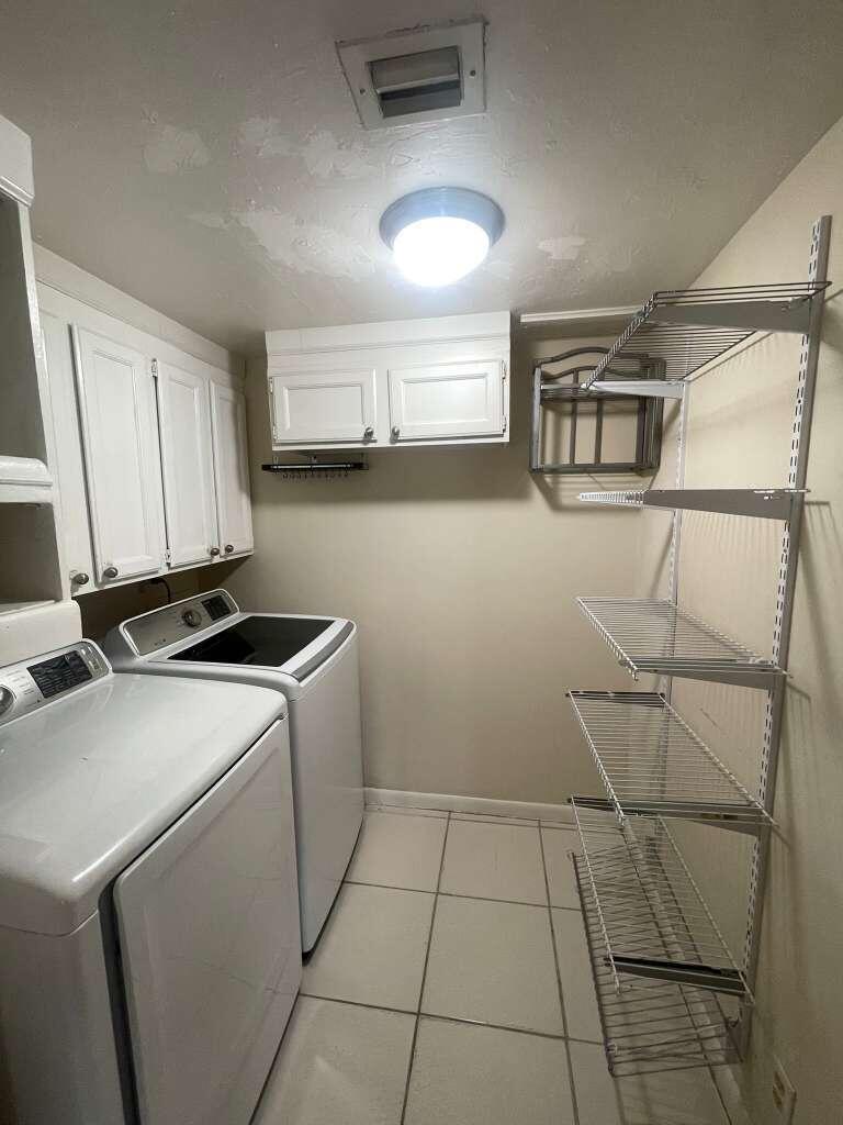 721 Sunny Pine Way, Unit A1 Greenacres, FL 33415 - Photo 6 of 10 a utility room with cabinets washer and dryer