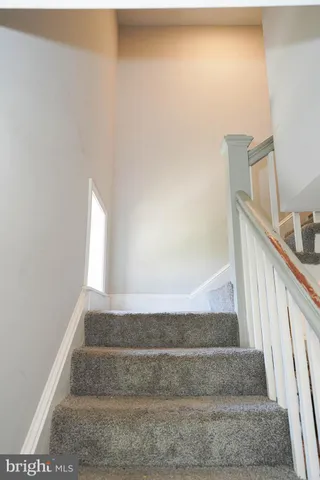 a view of staircase with white walls and railing