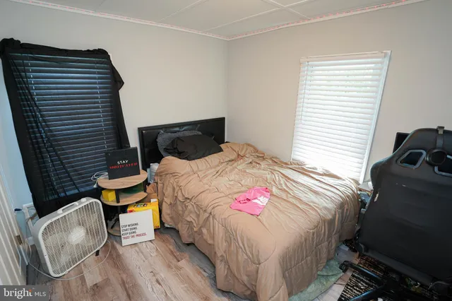 a bedroom with a bed and wooden floor