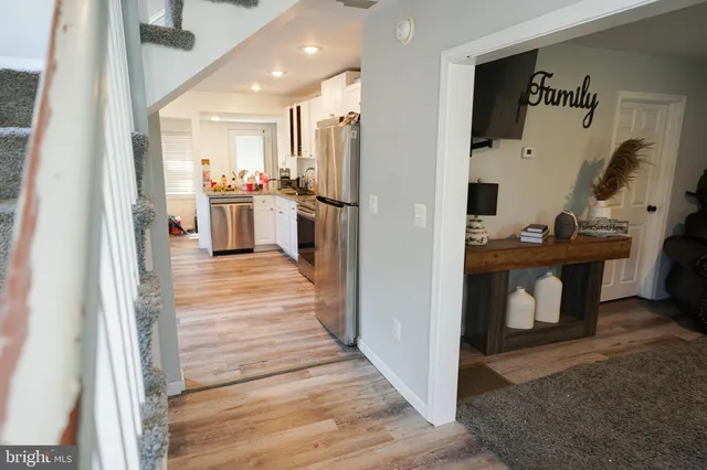 a open kitchen with white cabinets and stainless steel appliances