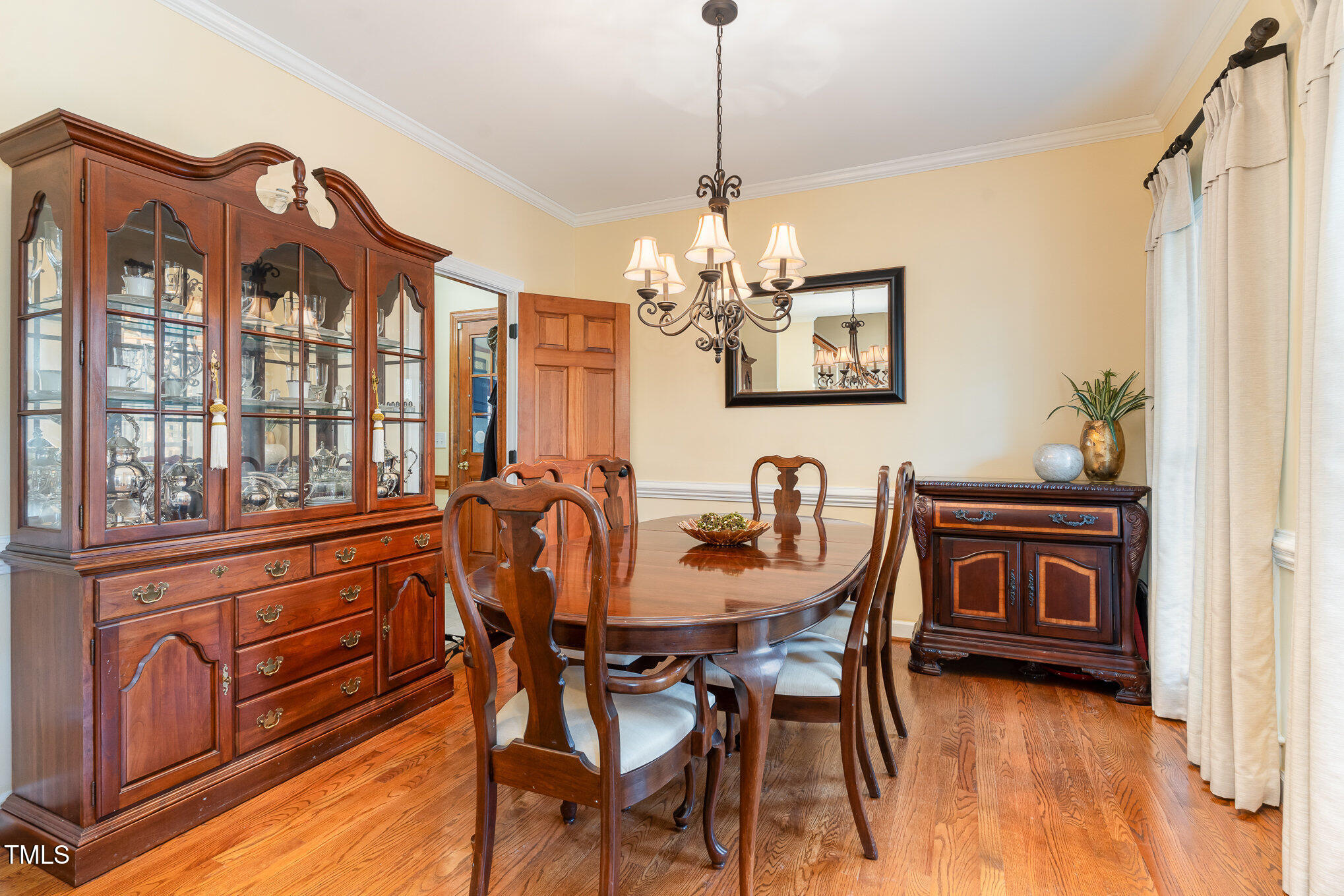 6132 Wolverhampton Drive Raleigh, NC 27603 - Photo 5 of 40 a view of a dining room with furniture chandelier and wooden floor