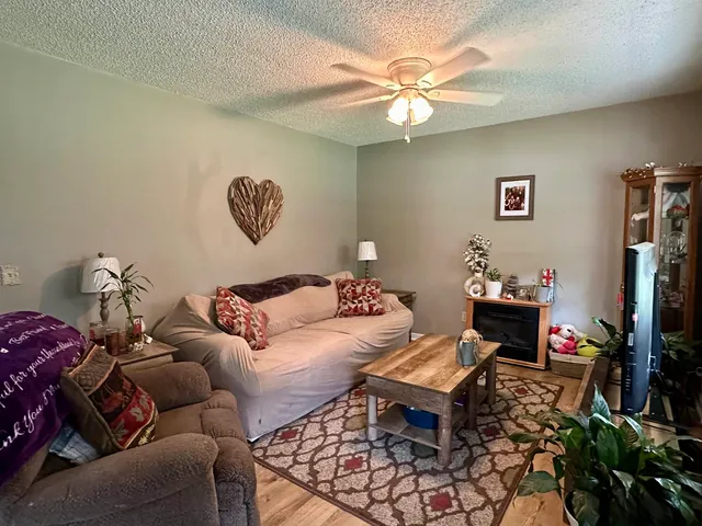 a living room with furniture a flat screen tv and a window