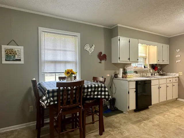 a kitchen with a dining table chairs and cabinets