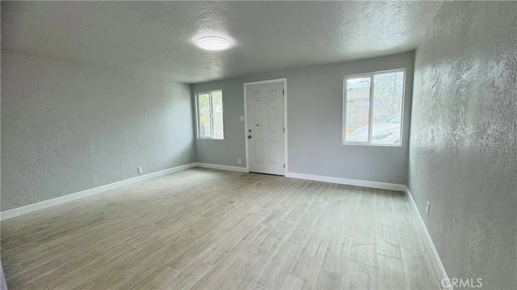 2523 Ogden Street Muscoy, CA 92407 - Photo 14 of 31 an empty room with wooden floor and windows
