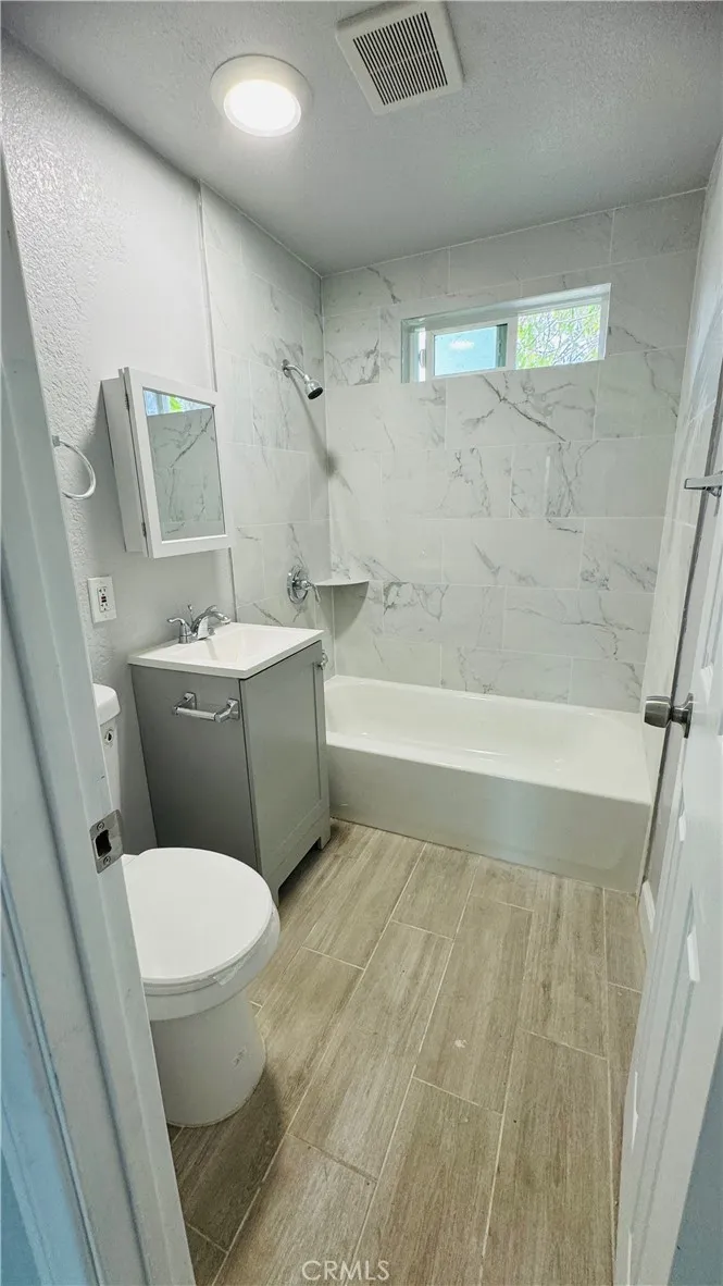 2523 Ogden Street Muscoy, CA 92407 - Photo 16 of 31 a bathroom with a toilet and a bathtub