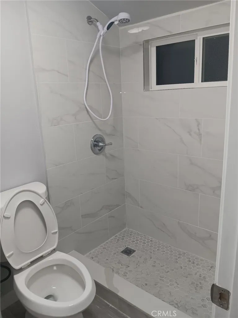 2523 Ogden Street Muscoy, CA 92407 - Photo 19 of 31 a bathroom with a granite countertop toilet a sink and shower