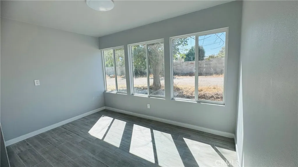 2523 Ogden Street Muscoy, CA 92407 - Photo 24 of 31 a view of an empty room with wooden floor and a window