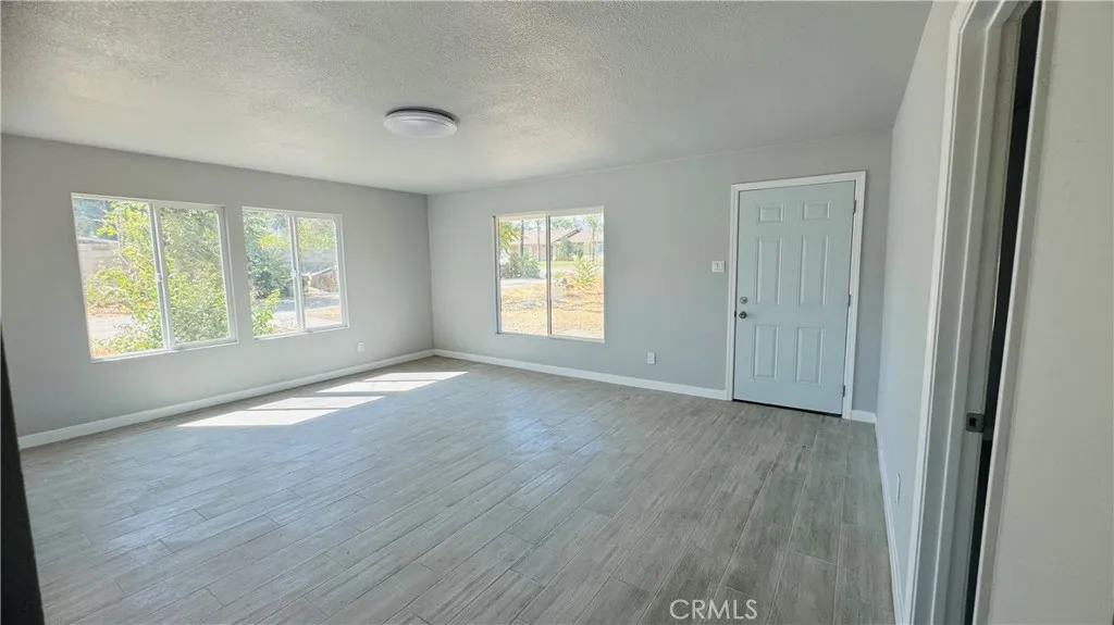 2523 Ogden Street Muscoy, CA 92407 - Photo 27 of 31 an empty room with wooden floor and windows