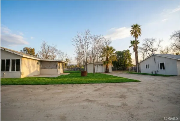 a view of a house with a yard and large tree