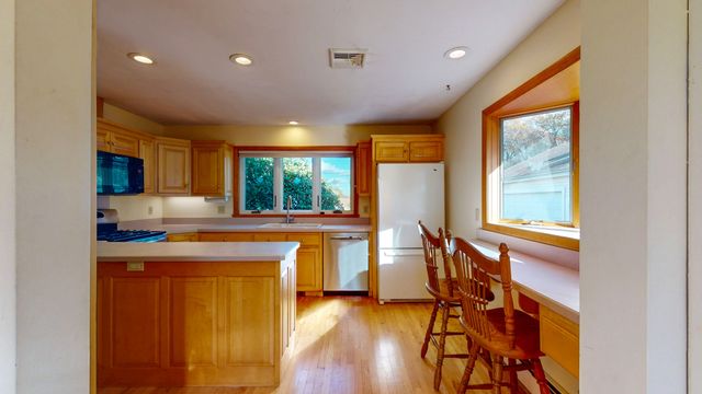 a kitchen with stainless steel appliances granite countertop sink stove and wooden cabinets