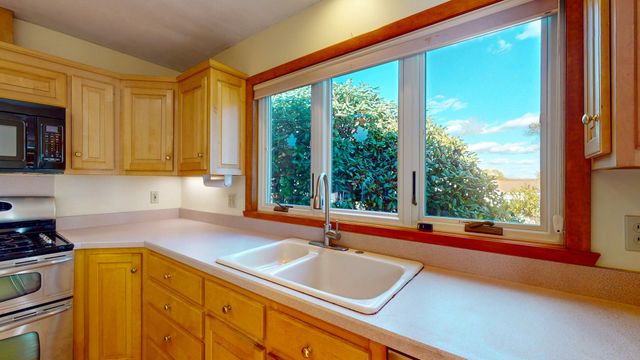a kitchen with a large window sink and cabinets