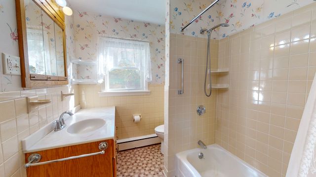 a bathroom with a granite countertop sink a mirror a bathtub and shower