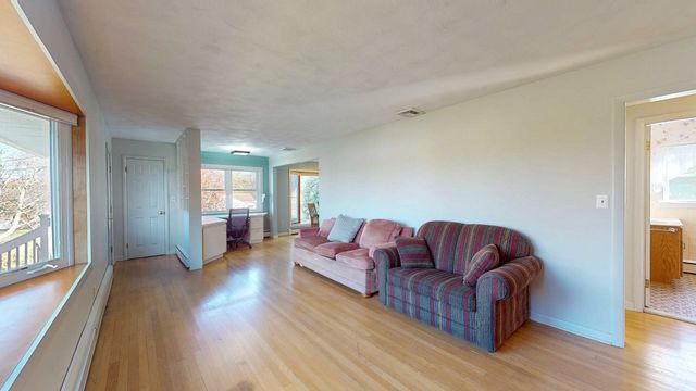 a living room with furniture a wooden floor and a large window