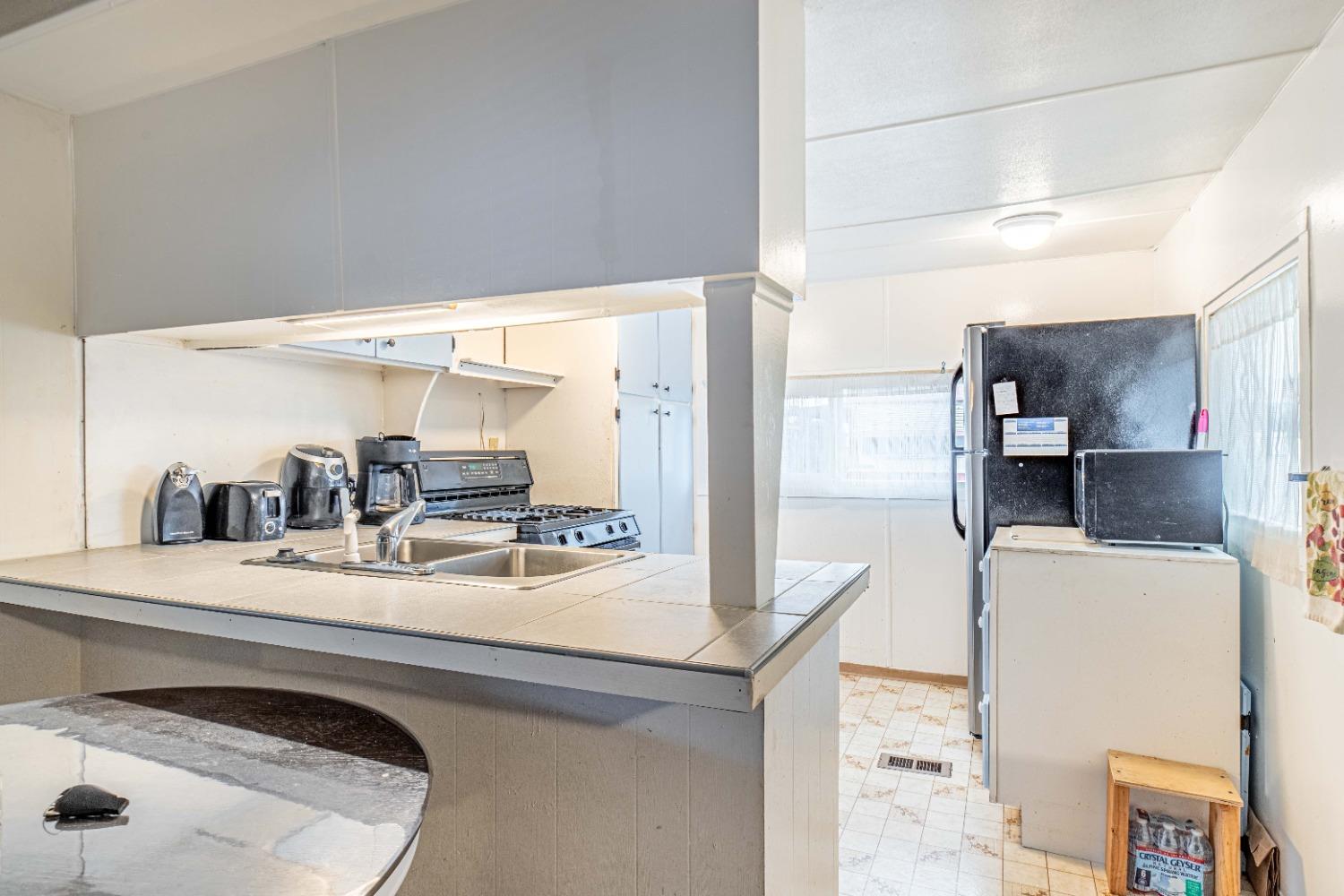 4449 South Carpenter Road, Unit D2 Modesto, CA 95358 - Photo 5 of 26 a room with stainless steel appliances kitchen island granite countertop a sink and cabinets