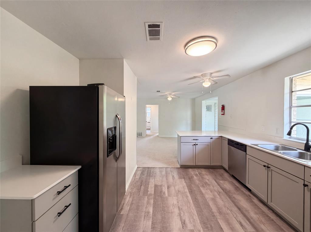 205 West Decatur Street Chico, TX 76431 - Photo 6 of 19 a large kitchen with a refrigerator a sink dishwasher oven and white cabinets