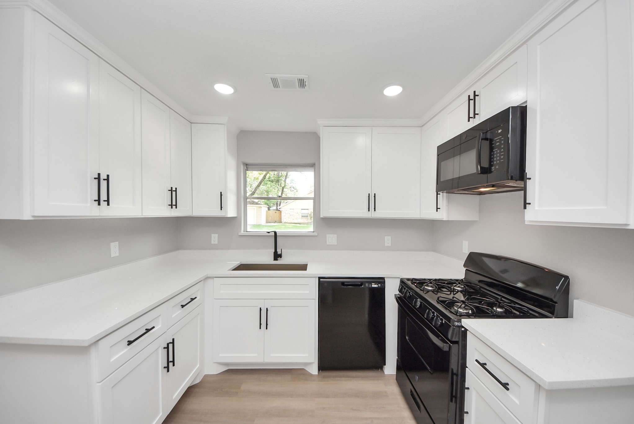 2402 Rolling Glen Drive Spring, TX 77373 - Photo 11 of 38 a kitchen with stainless steel appliances granite countertop white cabinets a sink dishwasher a stove and a refrigerator with wooden floor