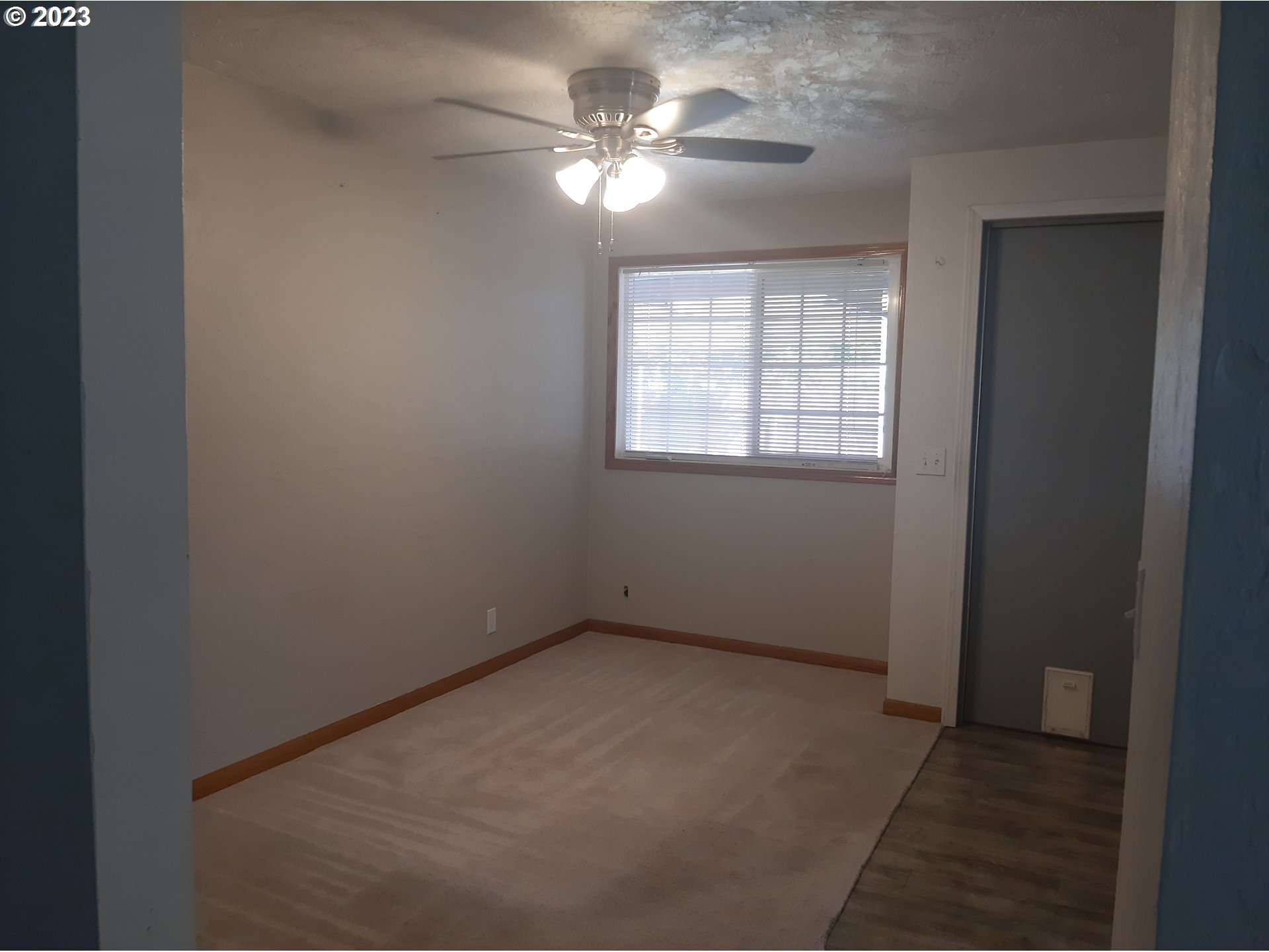 234 71st Street Springfield, OR 97478 - Photo 13 of 26 an empty room with a chandelier fan and windows