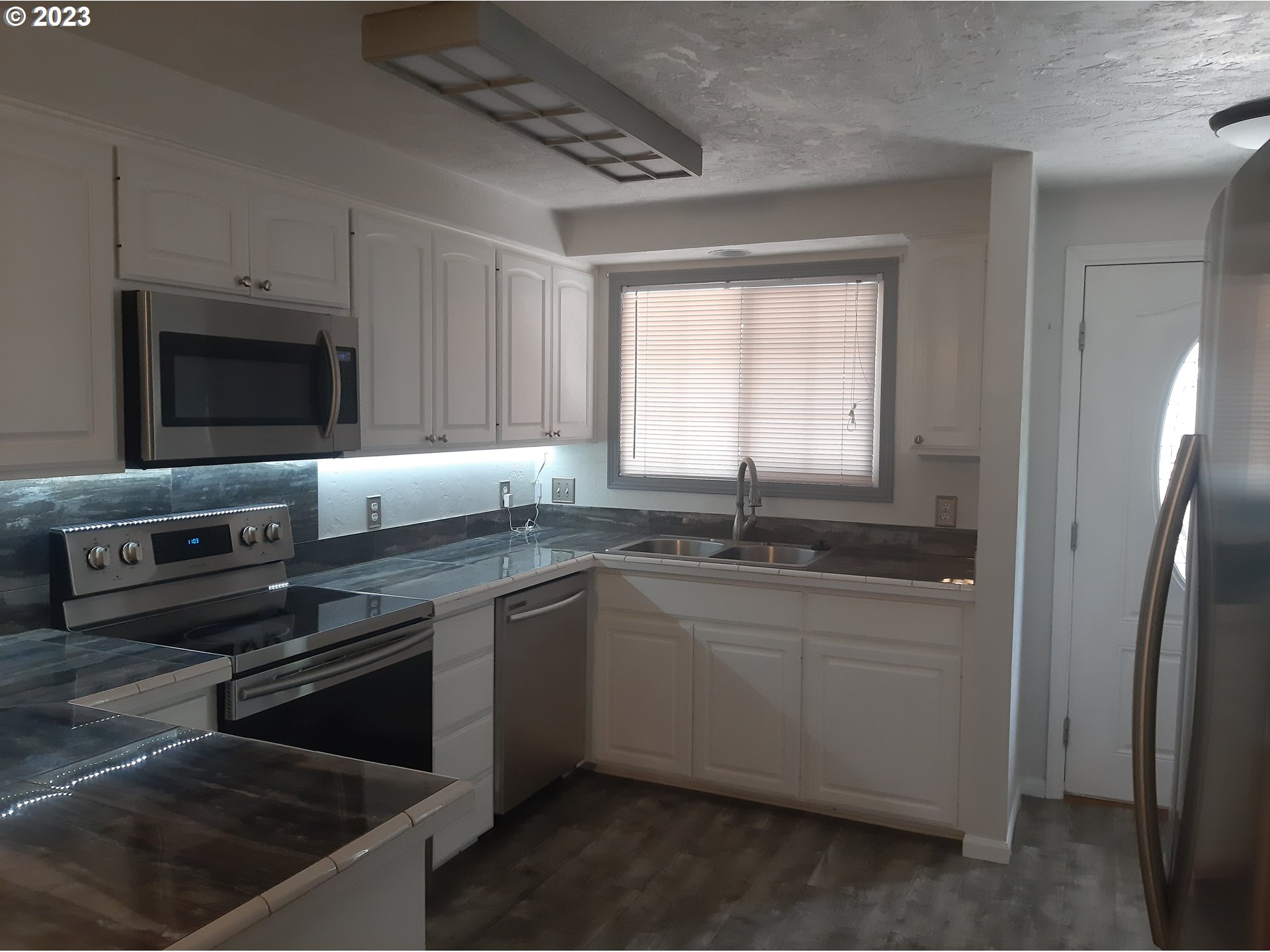 234 71st Street Springfield, OR 97478 - Photo 7 of 26 a kitchen with stainless steel appliances a stove a sink and a microwave
