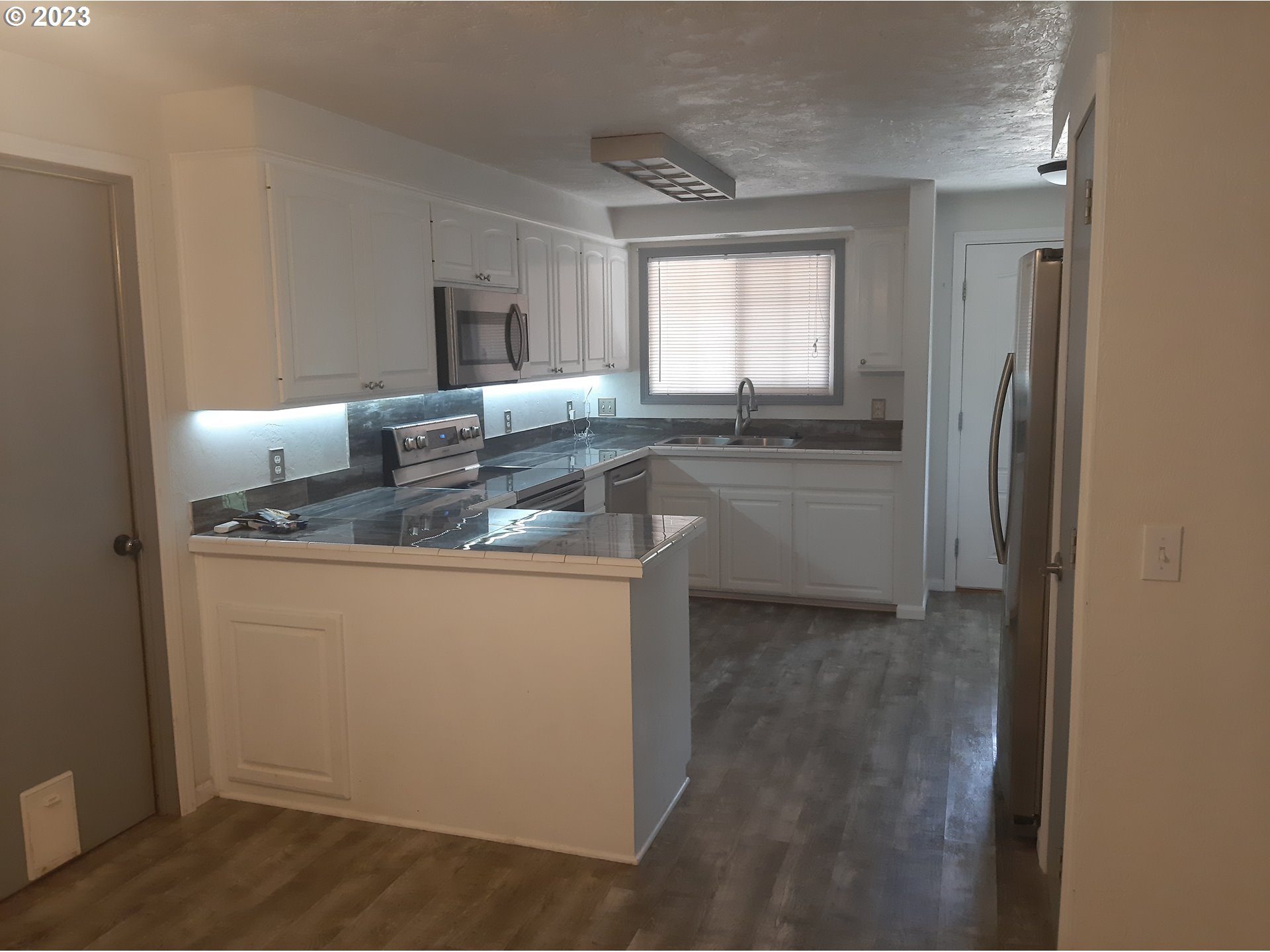 234 71st Street Springfield, OR 97478 - Photo 9 of 26 a kitchen with stainless steel appliances granite countertop a sink and a refrigerator