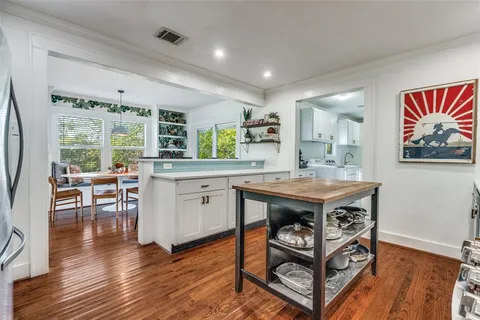 a kitchen with stainless steel appliances granite countertop a stove and a wooden floors
