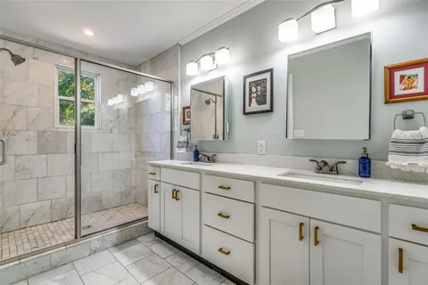 a spacious bathroom with a granite countertop sink mirror and shower