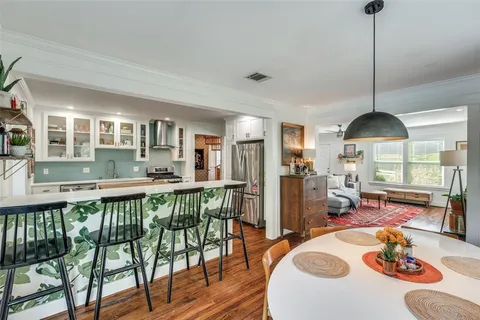 a view of a dining room and livingroom with furniture wooden floor a chandelier