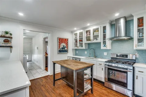 a kitchen with a stove and a wooden floors