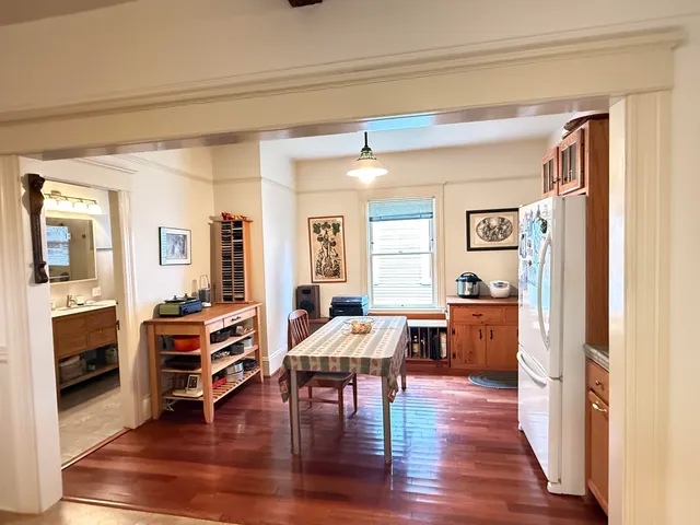 a view of a dining room with furniture a couch and wooden floor