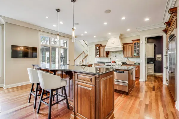 a kitchen with stainless steel appliances granite countertop a kitchen island a stove and a sink