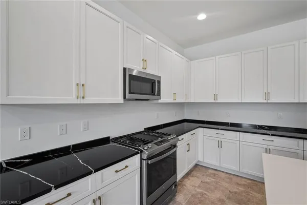 a large kitchen with stainless steel appliances a large counter top